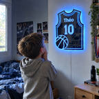 Boy amazed by his blue glowing basketball jersey mirror